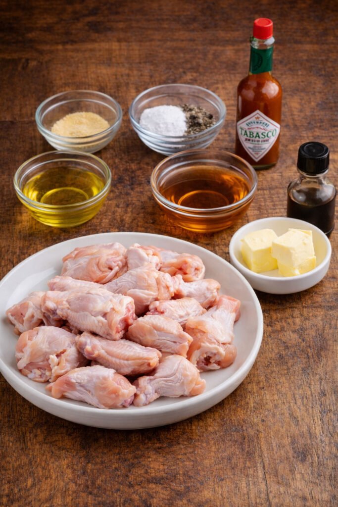 Alitas de pollo crudas con especias, mantequilla y salsas listas para preparar alitas Buffalo en kamado