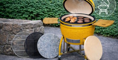 Kamado amarillo ocre con diferentes superficies de cocción apoyadas y parrilla en uso