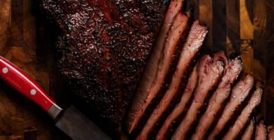 Brisket de ternera ahumado en kamado cortado en lonchas sobre tabla de madera