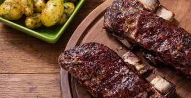 Costillas de ternera en kamado con patatas en costra sobre mesa rústica