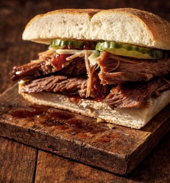 Sándwich de panceta de cerdo ahumado con pan crujiente sobre tabla de madera